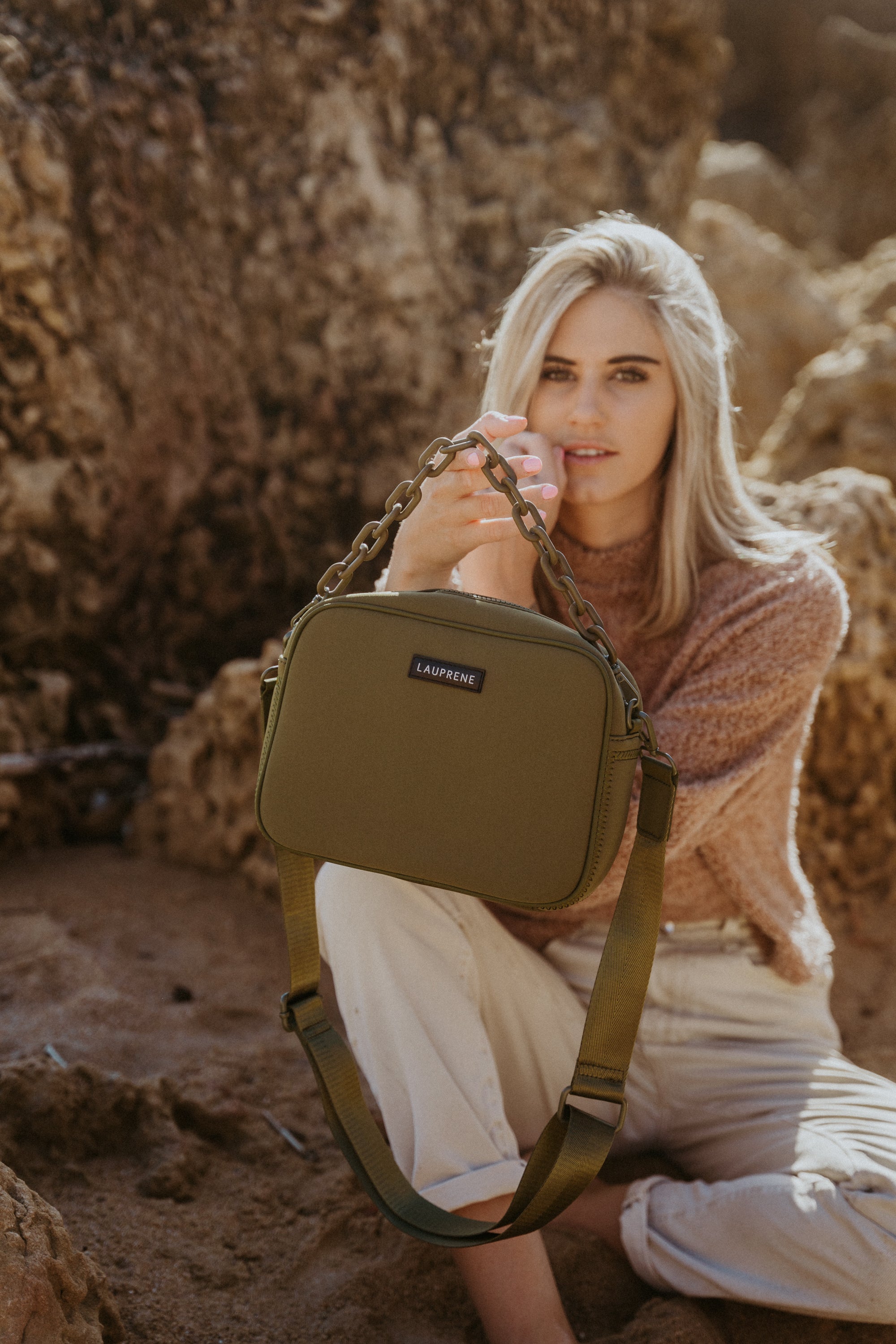 Woman holding a green bag in a natural setting