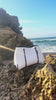 Classic white tote on the beach placed on a rock showing the quality 